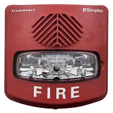 Simplex 4906-9131 fire alarm device with warning indicator, mounted on a wall in a safety equipment setting